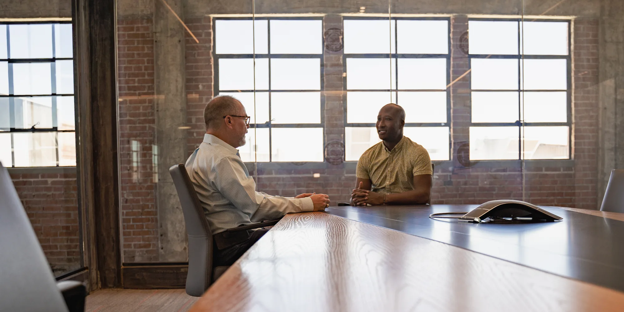 A StrongerWork facilitator working with a business leader at a conference table