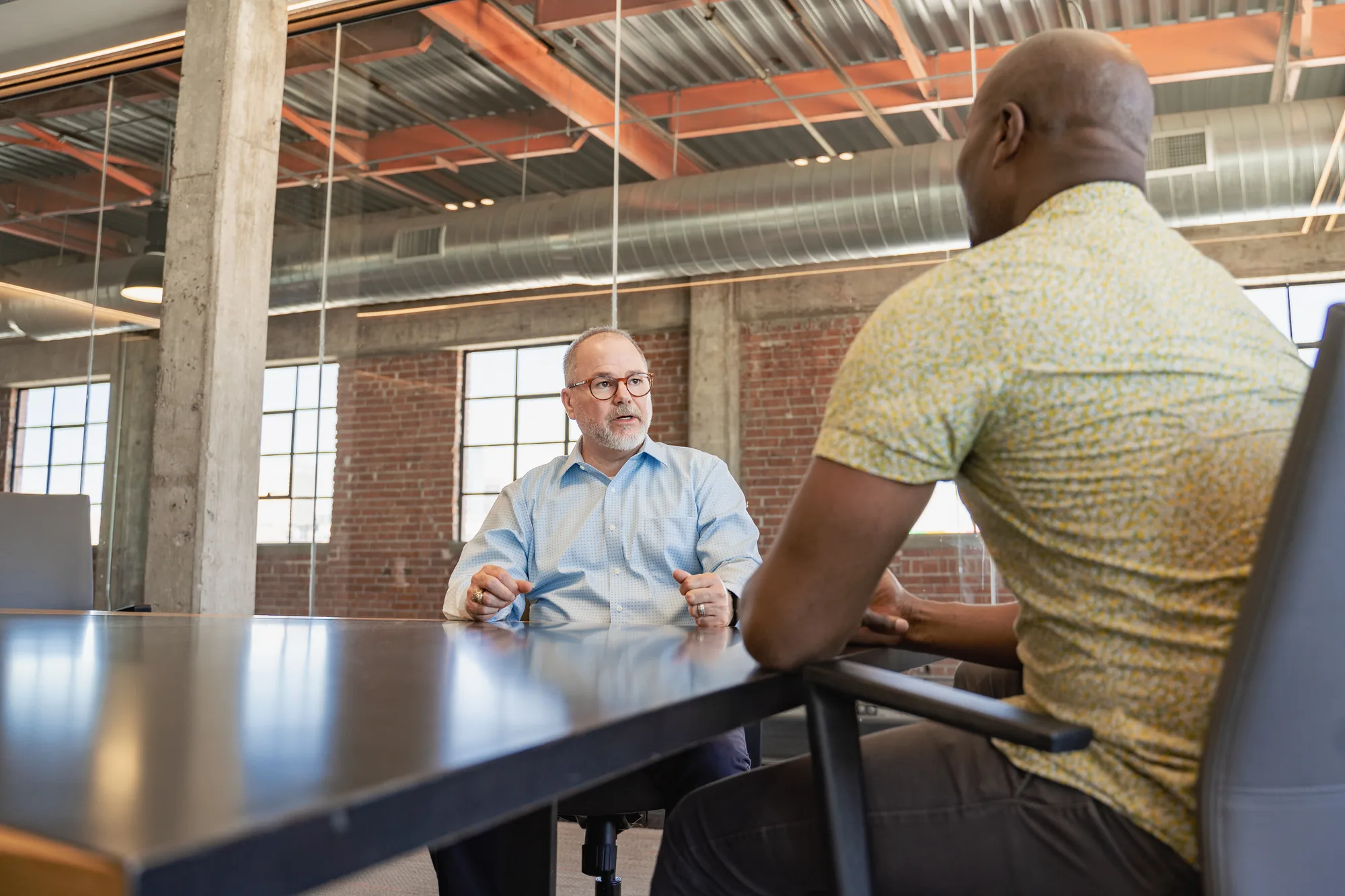 A one-on-one conversation across a conference table