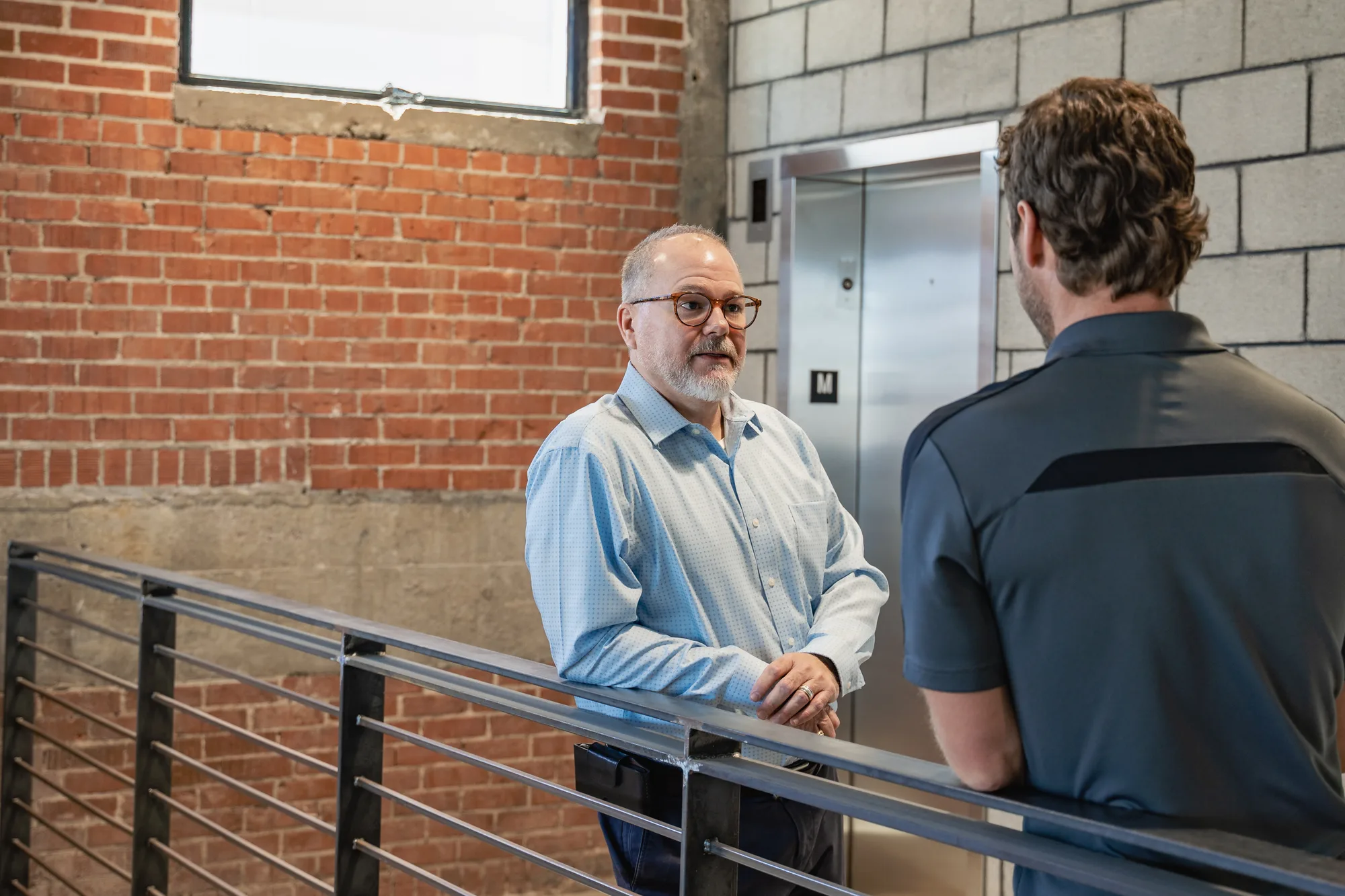 A business leader in conversation with a colleague